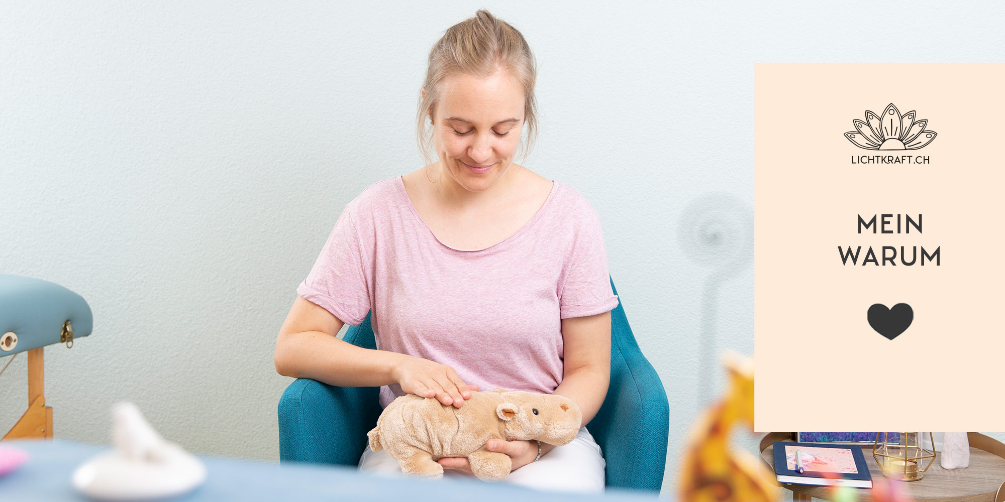 Melanie sitzt auf einem Sessel und hält ein Stofftier-Nilpferd in den Händen, das stellvertretend für das behandelnde Tier agiert während der Tierkommunikation