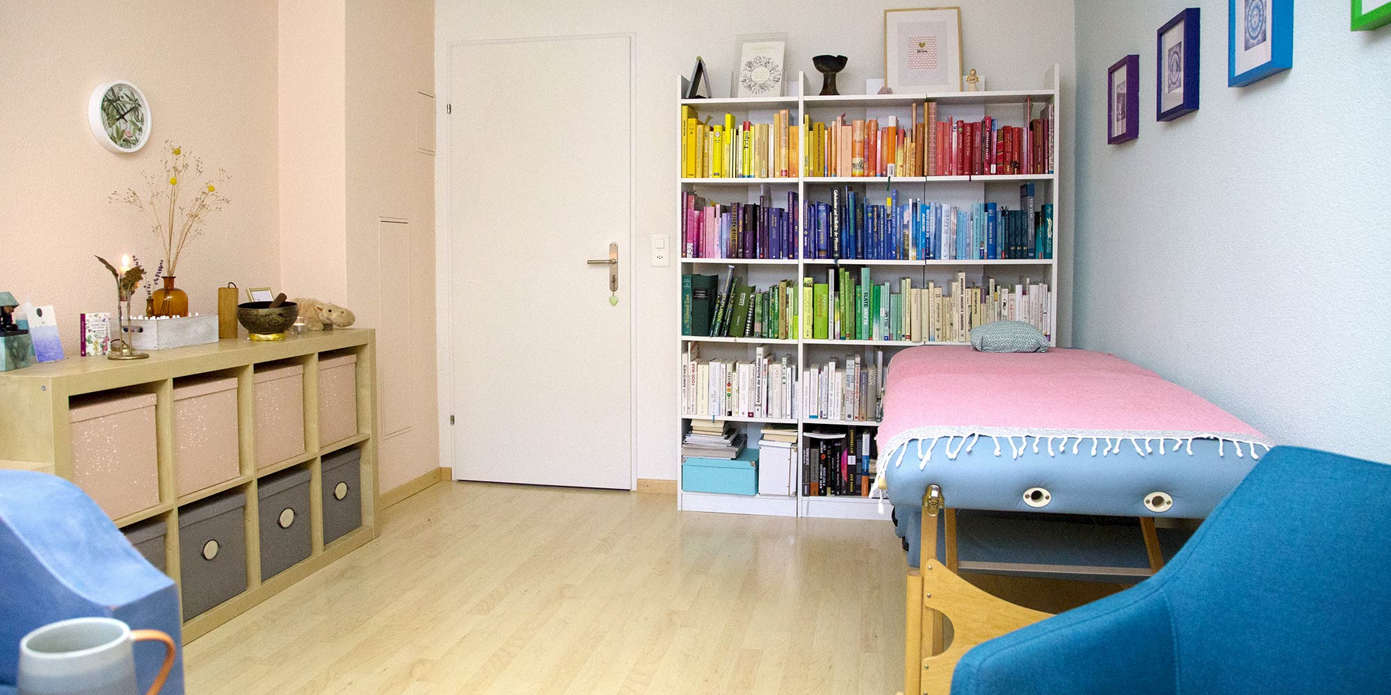 Foto eines Praxisraumes mit Behandlungsnische, Büchergestell und Sideboard.